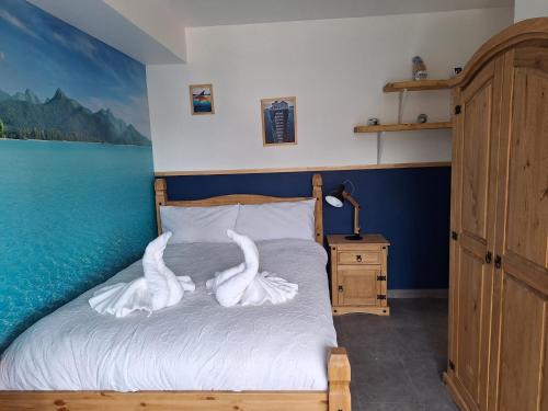 a bed with swans on it in a bedroom at Sunny Waves in Northampton