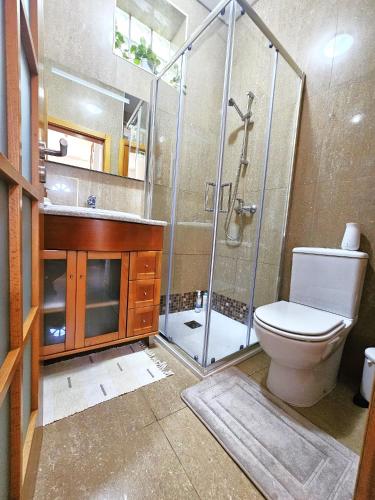 a bathroom with a toilet and a glass shower at Sunflower Sea View with magnificent terrace in Serra da Pescaria, Nazaré - Portugal in Nazaré