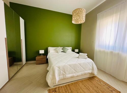 a green bedroom with a bed and a green wall at Chicco di Grano in Locorotondo