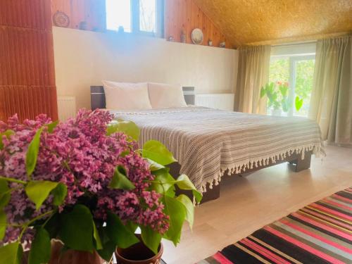 a bedroom with a bed with purple flowers at Agropensiunea La Prisaca in Orhei