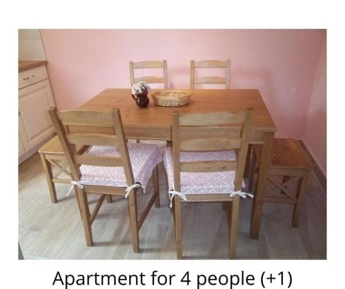 una mesa de comedor de madera con cuatro sillas y un cuenco encima en Two Angels, en Bled