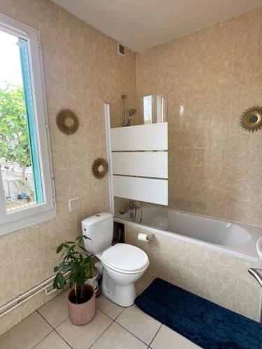 une salle de bain avec toilettes et baignoire dans l'établissement Maison avec jardin, jacuzzi entre Paris et Disney, à Champigny-sur-Marne