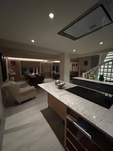 a large kitchen with a counter and a living room at Handelsmannens hus ved Otnesbrygga, Valsøyfjord in Otnes