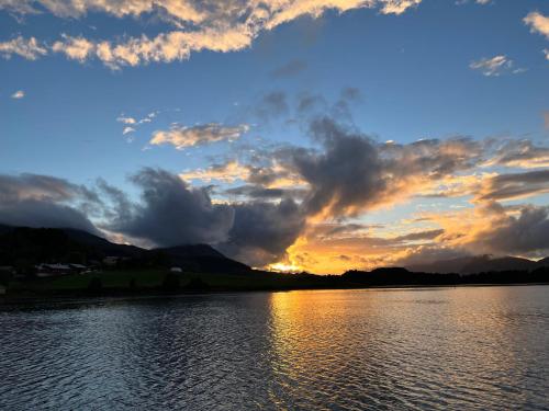 a sunset over a body of water at Handelsmannens hus ved Otnesbrygga, Valsøyfjord in Otnes
