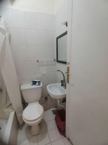 a white bathroom with a toilet and a sink at Rezeiky Hotel & Camp in Luxor