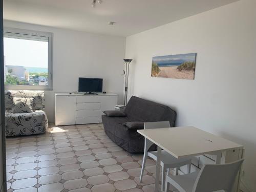un salon avec un canapé et une table dans l'établissement Studio vue mer grande terrasse, à La Grande Motte