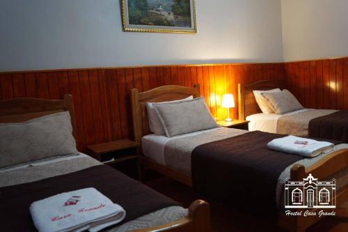 a hotel room with two beds with towels on them at Hostal Casa Grande in Iquique
