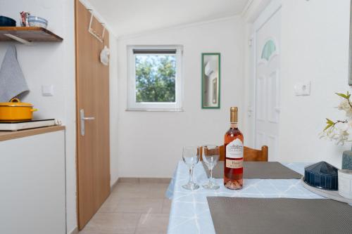 a bottle of wine sitting on a table with wine glasses at Apartment Tom in Starigrad-Paklenica