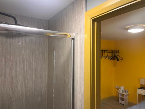 a bathroom with a shower and a yellow wall at Tumbledown Hotel in Shrewsbury