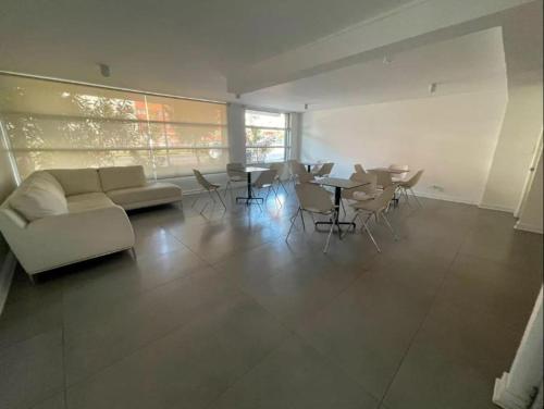 un salon avec un canapé, des tables et des chaises dans l'établissement 13 Apartamento en Santiago en fente al Metro, à Santiago