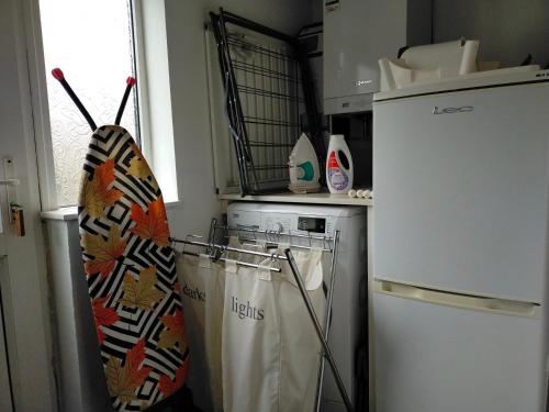 a kitchen with a refrigerator and a umbrella at Newly Renovated 3 Bedroom House, 6 beds with 2 showers, near University Town Centre in Lancaster