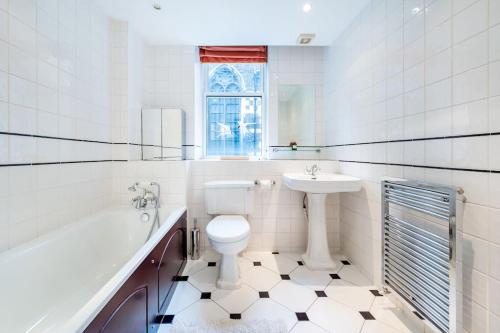 a bathroom with a sink and a toilet and a bath tub at Arcore London Premium Apartments in The City in London