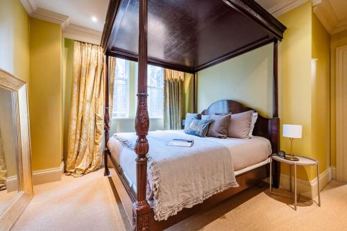 a bedroom with a canopy bed and a window at Arcore London Premium Apartments in The City in London