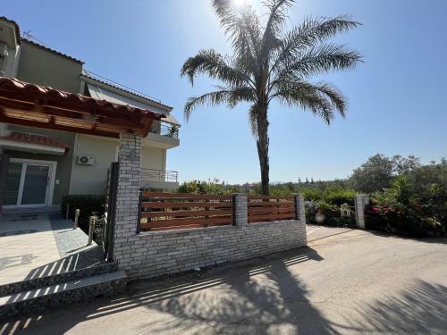 a fence in front of a house with a palm tree at Joyful Guest Houses by 8essentially in Chania Town