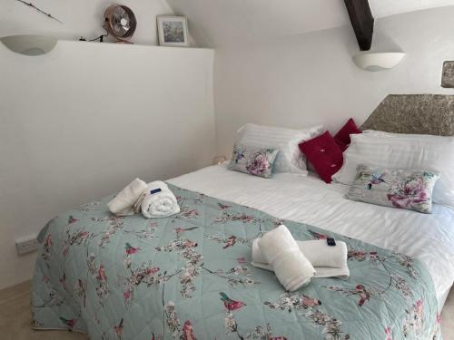 Beautiful Character Cottage - with Hot Tub في بودمين: غرفة نوم بها سرير مع مناشف عليه