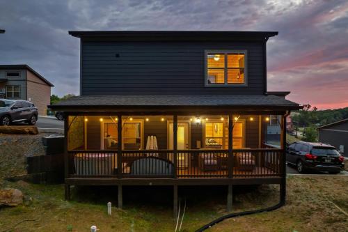 a house with a wrap around deck at dusk at Family or couple retreat next to Downtown, Dollywood & Smoky Mountains! in Sevierville
