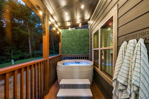 a porch with a bath tub on a deck at Family or couple retreat next to Downtown, Dollywood & Smoky Mountains! in Sevierville