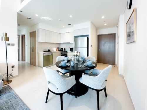 a kitchen and dining room with a black table and chairs at Breathtaking Burj View, Sky High Luxury 2BR Apartment by 2nd Best Home in Dubai