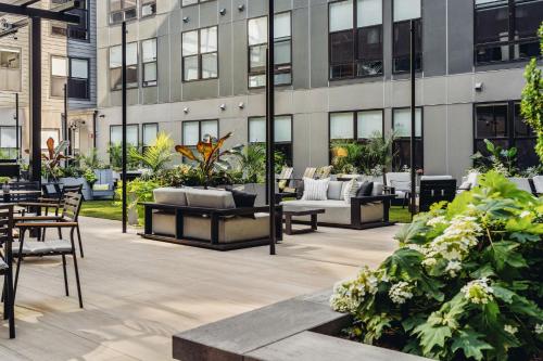 a patio with couches and plants in front of a building at Luxury Apartments by Hyatus at The Asher in Stamford