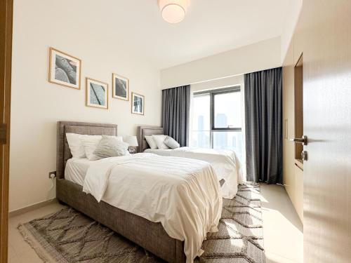 a bedroom with two beds and a window at Breathtaking Burj View, Sky High Luxury 2BR Apartment by 2nd Best Home in Dubai