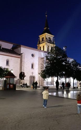 a child standing in front of a building with a tower at Un Rincón en Alcalá in Alcalá de Henares