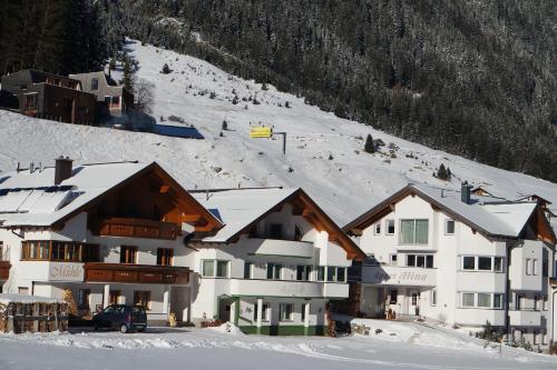ein großes Gebäude mit Schnee auf einem Berg in der Unterkunft Apart Alina in Galtür
