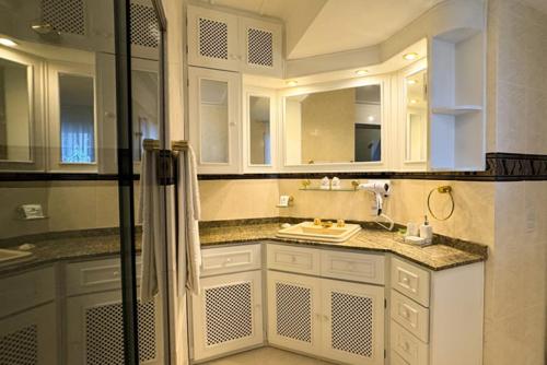 a white bathroom with a sink and a shower at Fares Turis Hotel in Uruguaiana