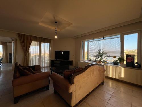 a living room with two couches and a large window at Joyful Guest Houses by 8essentially in Chania Town