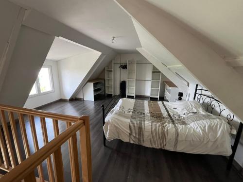 une chambre avec un lit dans un grenier dans l'établissement Jolie petite maisonnette, à Bollezeele