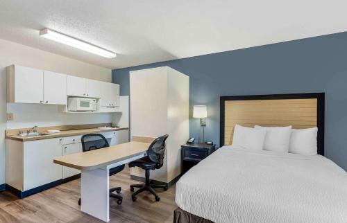 a hotel room with a bed and a desk and a kitchen at Extended Stay America Select Suites - Chicago - Rolling Meadows in Rolling Meadows