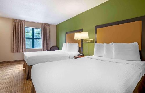two beds in a hotel room with green walls at Extended Stay America Suites - Columbia - Columbia Parkway in Columbia