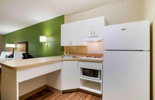 a kitchen with white cabinets and a white refrigerator at Extended Stay America Suites - Columbia - Columbia Parkway in Columbia