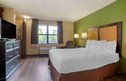 a hotel room with a large bed and a television at Extended Stay America Suites - Columbia - Columbia Parkway in Columbia