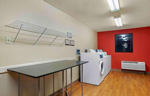 a laundry room with a white refrigerator and red wall at Extended Stay America Suites - Columbia - Columbia Parkway in Columbia