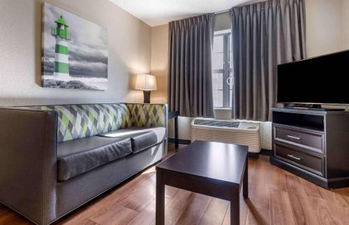 a living room with a couch and a flat screen tv at Extended Stay America Premier Suites - Charlotte - Pineville - Pineville Matthews Rd. in Charlotte