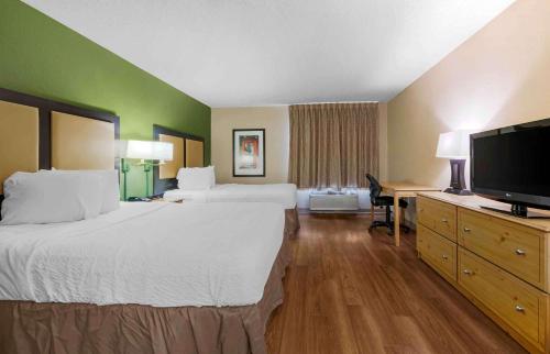 a hotel room with two beds and a flat screen tv at Extended Stay America Select Suites - Orlando - Southpark - Equity Row in Orlando