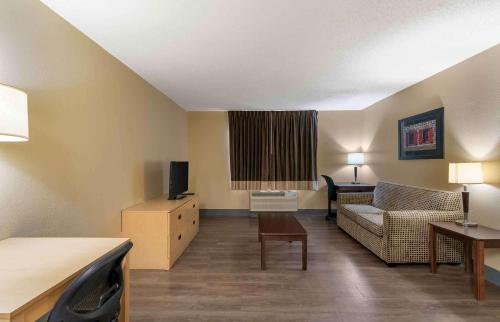 a living room with a couch and a tv at Extended Stay America Select Suites - Orlando - Southpark - Equity Row in Orlando