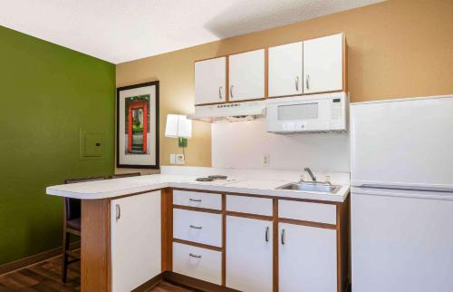 a small kitchen with white cabinets and a sink at Extended Stay America Suites - Clearwater - Carillon Park in Clearwater