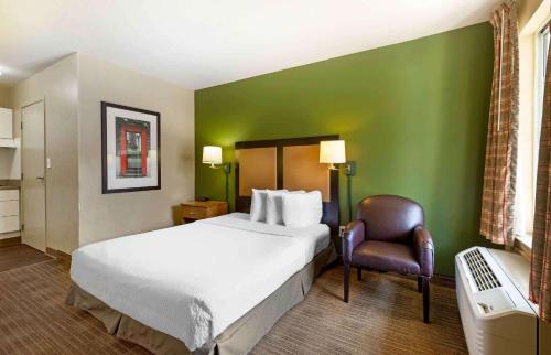 a hotel room with a bed and a chair at Extended Stay America Select Suites - Baltimore - BWI Airport - International Dr in Linthicum Heights