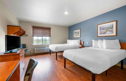 a hotel room with two beds and a flat screen tv at Extended Stay America Select Suites - Indianapolis - Plainfield in Plainfield