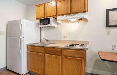 a kitchen with a white refrigerator and a sink at Studio 6 Extended Stay Bossier City, LA - Shreveport in Bossier City