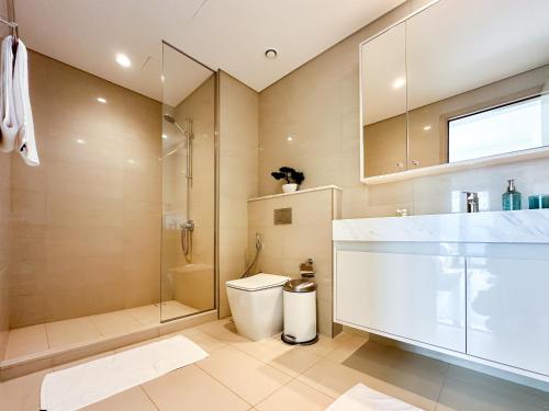 a bathroom with a shower and a toilet and a sink at Breathtaking Burj View, Sky High Luxury 2BR Apartment by 2nd Best Home in Dubai