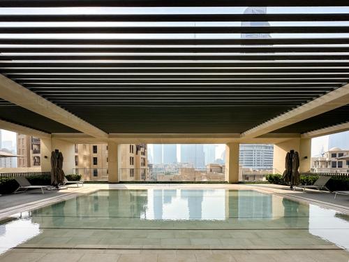a swimming pool in a building with a large ceiling at Breathtaking Burj View, Sky High Luxury 2BR Apartment by 2nd Best Home in Dubai