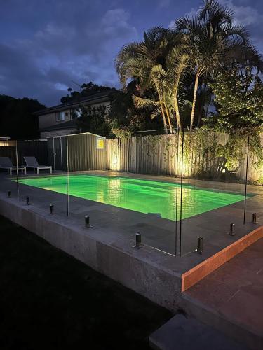 a swimming pool lit up at night with green illumination at 81 Horace St - Wifi, Pool and air conditioning in Shoal Bay