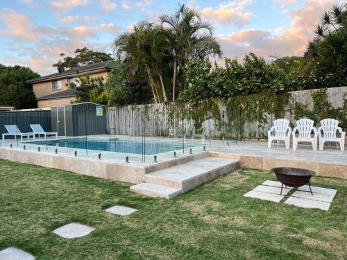 a backyard with a swimming pool with chairs and a grill at 81 Horace St - Wifi, Pool and air conditioning in Shoal Bay