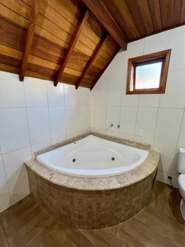 a large bath tub in a bathroom with a toilet at Pousada Vista do Paraíso in Monte Verde