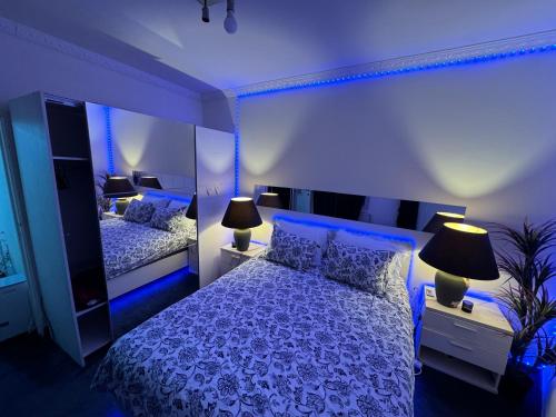 a blue bedroom with two beds with blue lighting at Rise Lodge in Brussels
