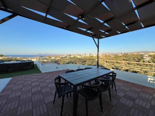 a patio with a wooden table and chairs on a roof at Joyful Guest Houses by 8essentially in Chania Town
