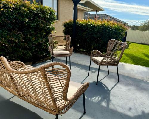 three wicker chairs and chairs sitting on a sidewalk at Budgaribah in Old Bar