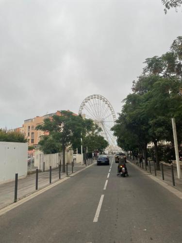 une rue de la ville avec une roue ferris en arrière-plan dans l'établissement Appartement Cap d'Agde, au Cap d'Agde